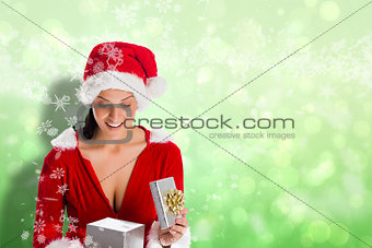 Composite image of smiling woman opening christmas present