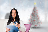Composite image of woman sitting with tablet pc