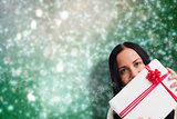 Composite image of woman holding a large present