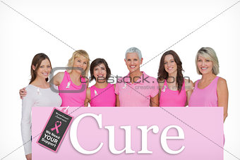 Composite image of smiling women wearing pink for breast cancer awareness