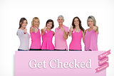 Composite image of positive women posing with pink top for breast cancer