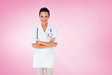 Composite image of pretty nurse with arms crossed