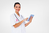 Composite image of pretty nurse using tablet pc