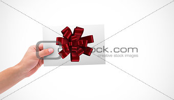 Composite image of hand holding card