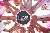 Composite image of happy women in circle wearing pink for breast cancer