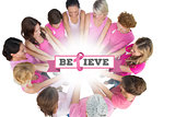 Composite image of cheerful women joined in a circle wearing pink for breast cancer