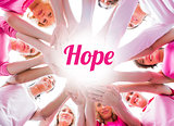 Diverse women smiling in circle wearing pink for breast cancer