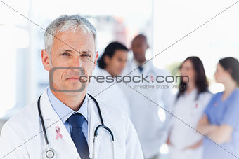 Composite image of mature doctor looking straight ahead