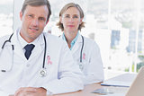 Composite image of group of doctors posing at their desk