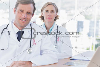 Composite image of group of doctors posing at their desk