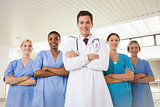 Composite image of smiling doctor and nurses with arms crossed