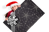 Composite image of festive little girl showing card
