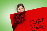 Composite image of cute little girl showing card