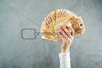 Woman holding fifty euros stack