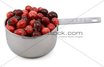 Whole fresh cranberries in a cup measure