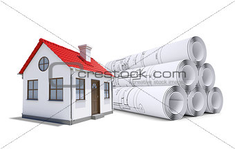 Small model house with red roof near scrolls of architectural drawings