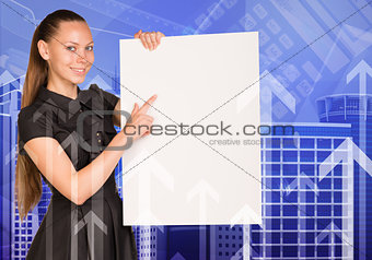 Beautiful businesswoman in dress holding empty paper sheet. Buildings and arrows as backdrop