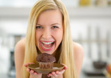 Portrait of happy young woman holding muffin