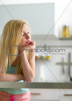 Portrait of sleepy young woman in kitchen