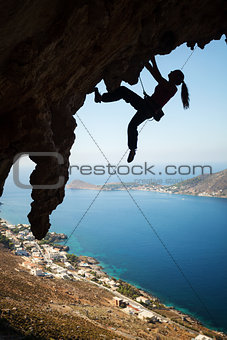 Silhouette of a young female rock climber on a cliff. Kalymnos Island