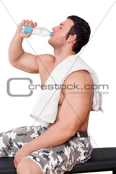 Attractive athlete drinking water isolated.