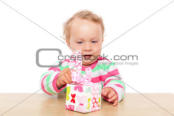 Baby girl unwrapping present.