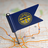 Nebraska Small Flag on a Map Background.