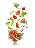 glass salad bowl in flight with vegetables: tomato, pepper, cucu