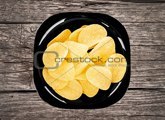 chips on a black plate on a wooden background