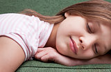 face of a little sweet girl sleeping on a sofa