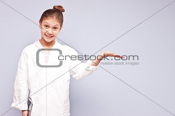little scientist girl in a smock showing something