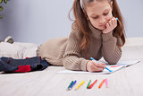 little girl colouring on her notebook