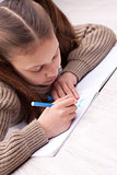 little girl writing concentrated on her exercise book