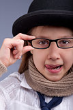 girl stucking out her tongue with glasses and hat