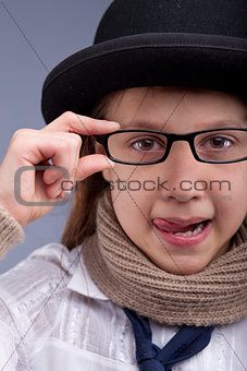 girl stucking out her tongue with glasses and hat
