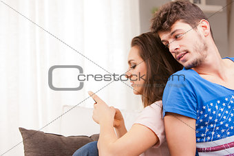 girl using her mobile phone ignoring his boyfriend