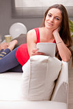 woman on a couch enjoying content on a tablet