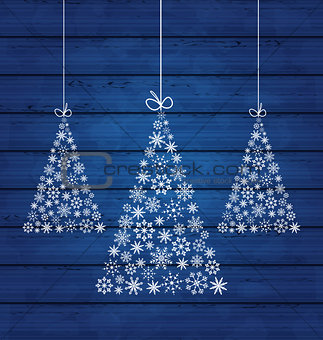Holiday wooden background with Christmas pines made of snowflake