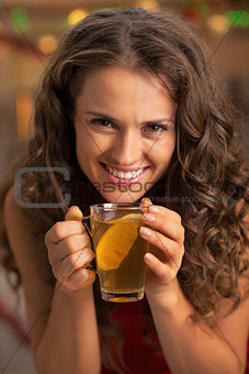Portrait of happy young woman drinking tea