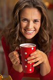 Portrait of happy young woman with cup of hot chocolate
