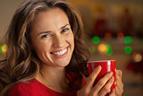 Portrait of smiling young woman with cup of hot chocolate in chr