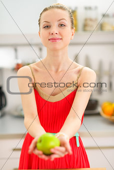 Young woman showing apple