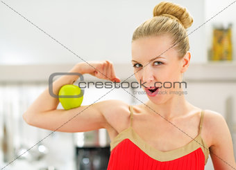 Young woman showing strength of healthy eating