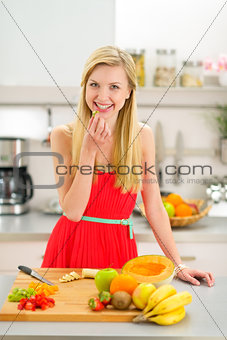 Happy young woman making fruits salad