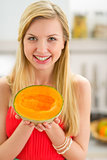 Portrait of happy young woman showing melon