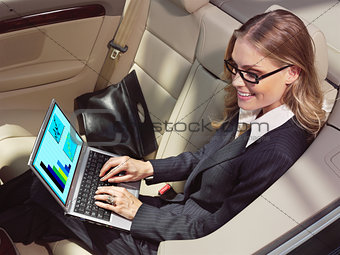 businesswoman in her car with laptop