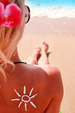 sun cream on the female back on the seaside