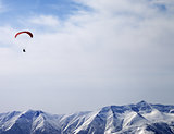 Paraglider silhouette of mountains in sunlight sky