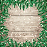 Fir tree branches and snowflakes on the wooden board.