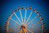 big wheel with multicolored cabins in amusement park 